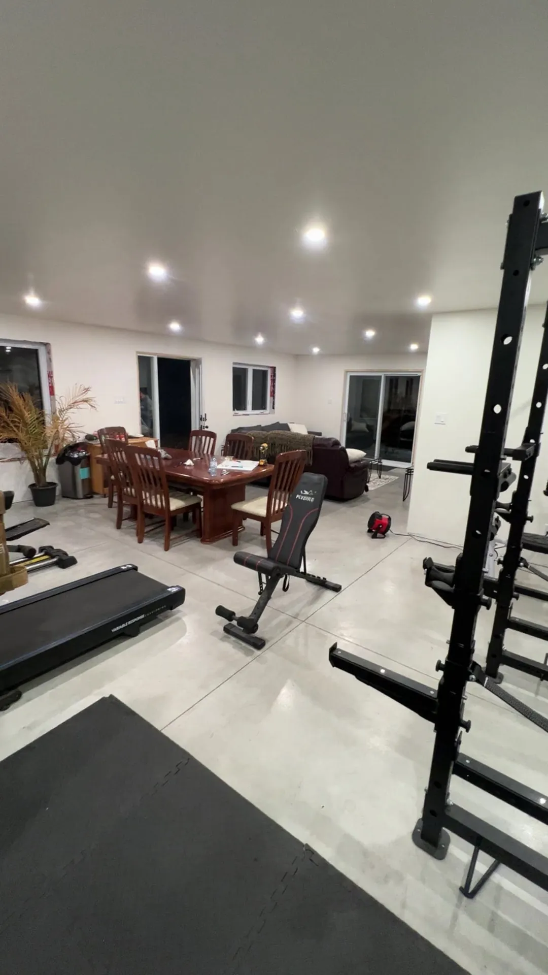 Finished basement living space illuminated by recessed pot lights.