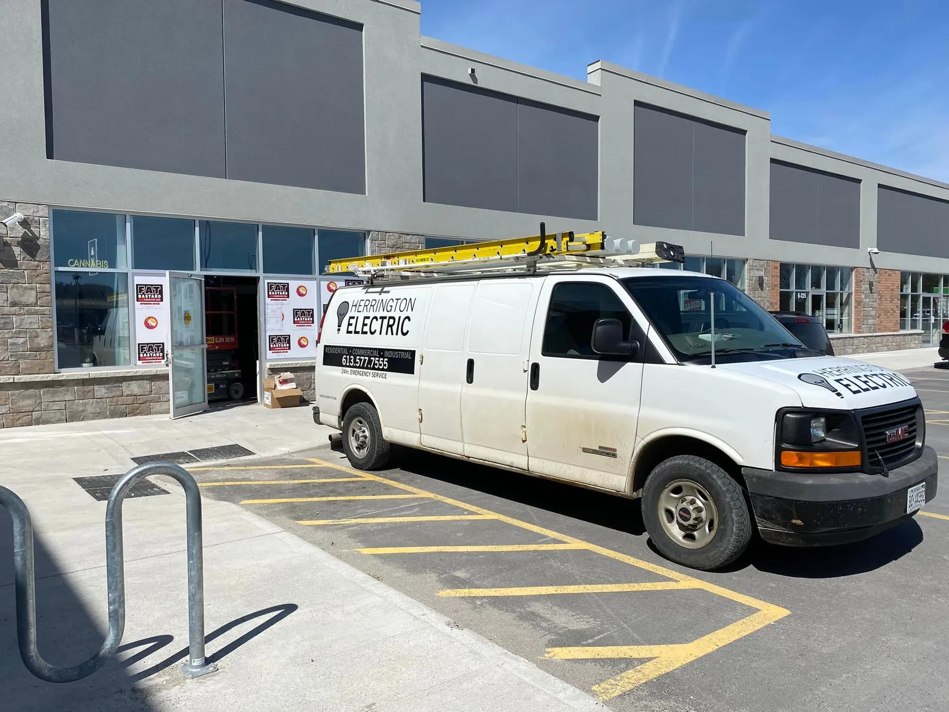 Herrington Electric service van parked outside a retail plaza project.