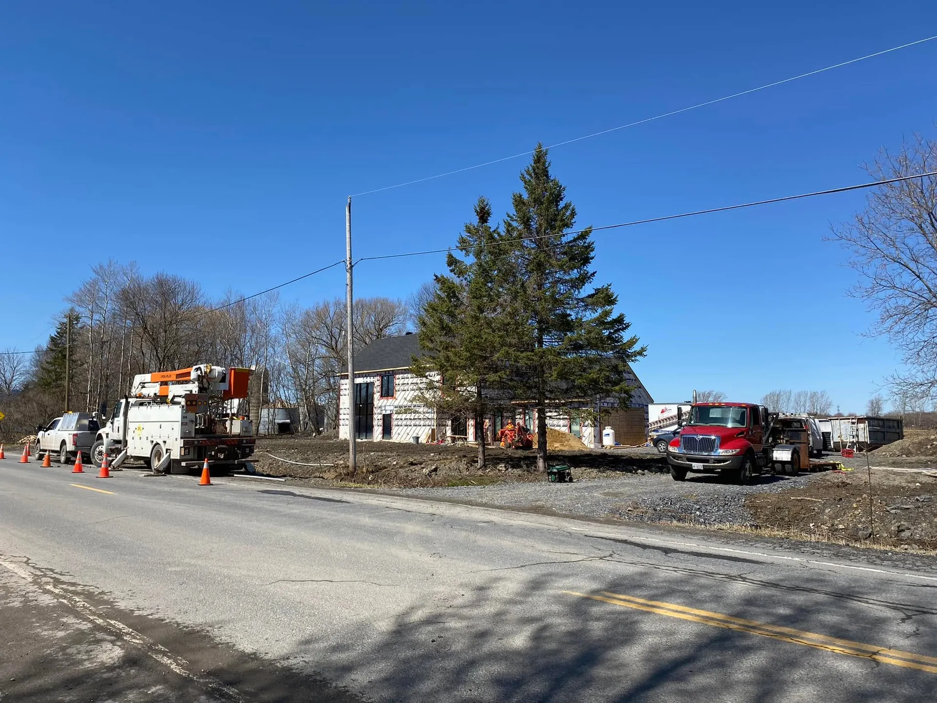 Electrical service and bucket trucks staged for roadside work at a commercial property.