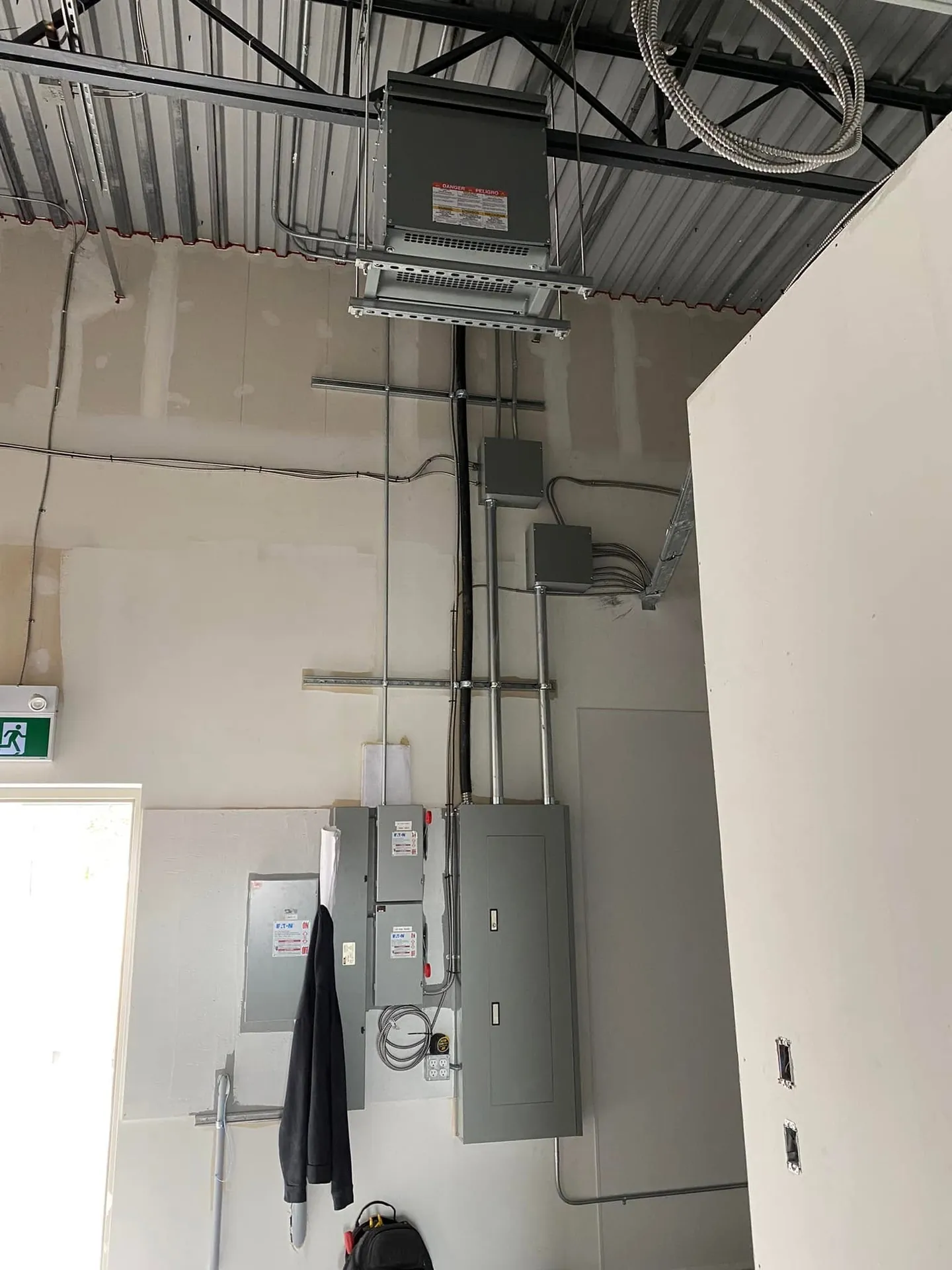 Commercial electrical service equipment connected with neatly routed metal conduit.