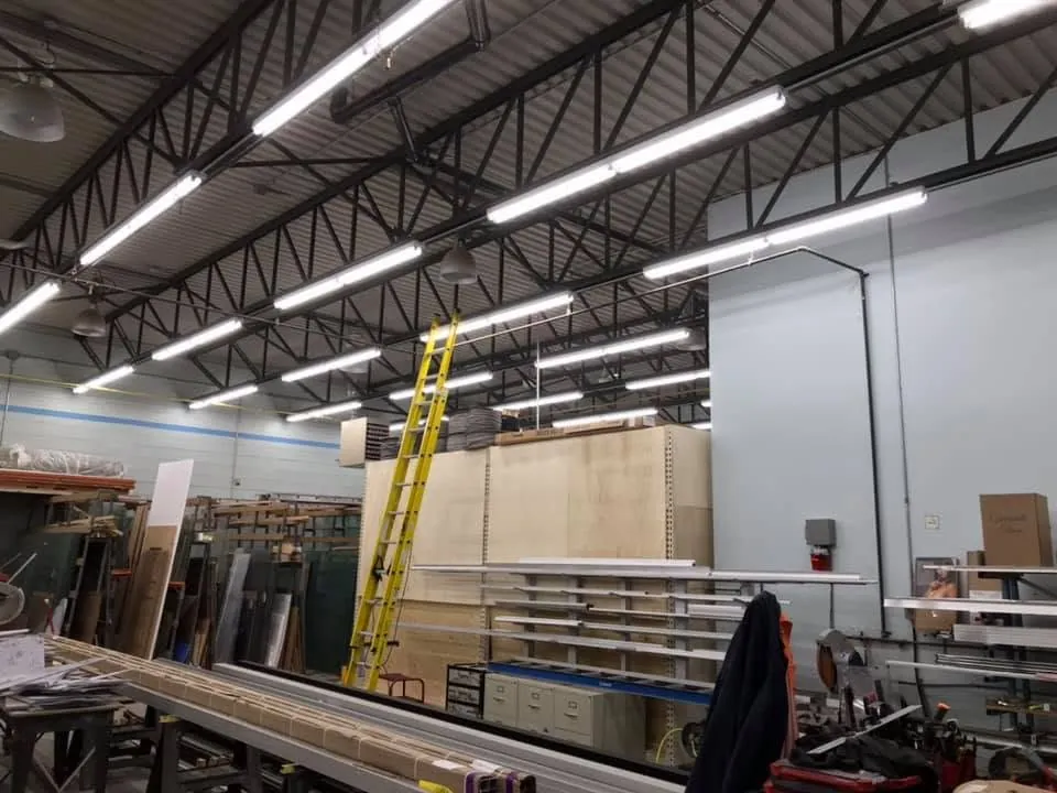 Wide workshop view showing rows of bright LED linear lighting.