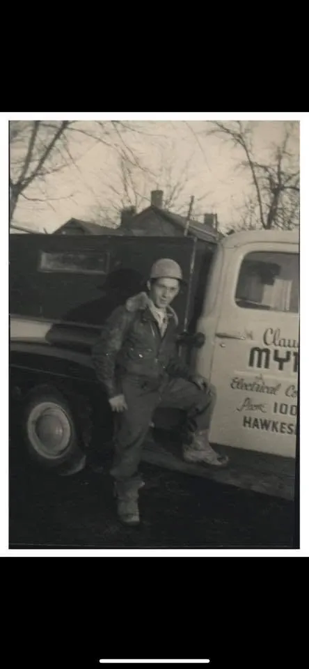 An archive photograph of Ryan's grandfather beside a service vehicle