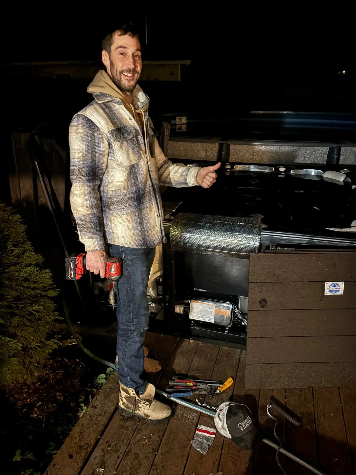 Electrician servicing a residential standby generator at night.