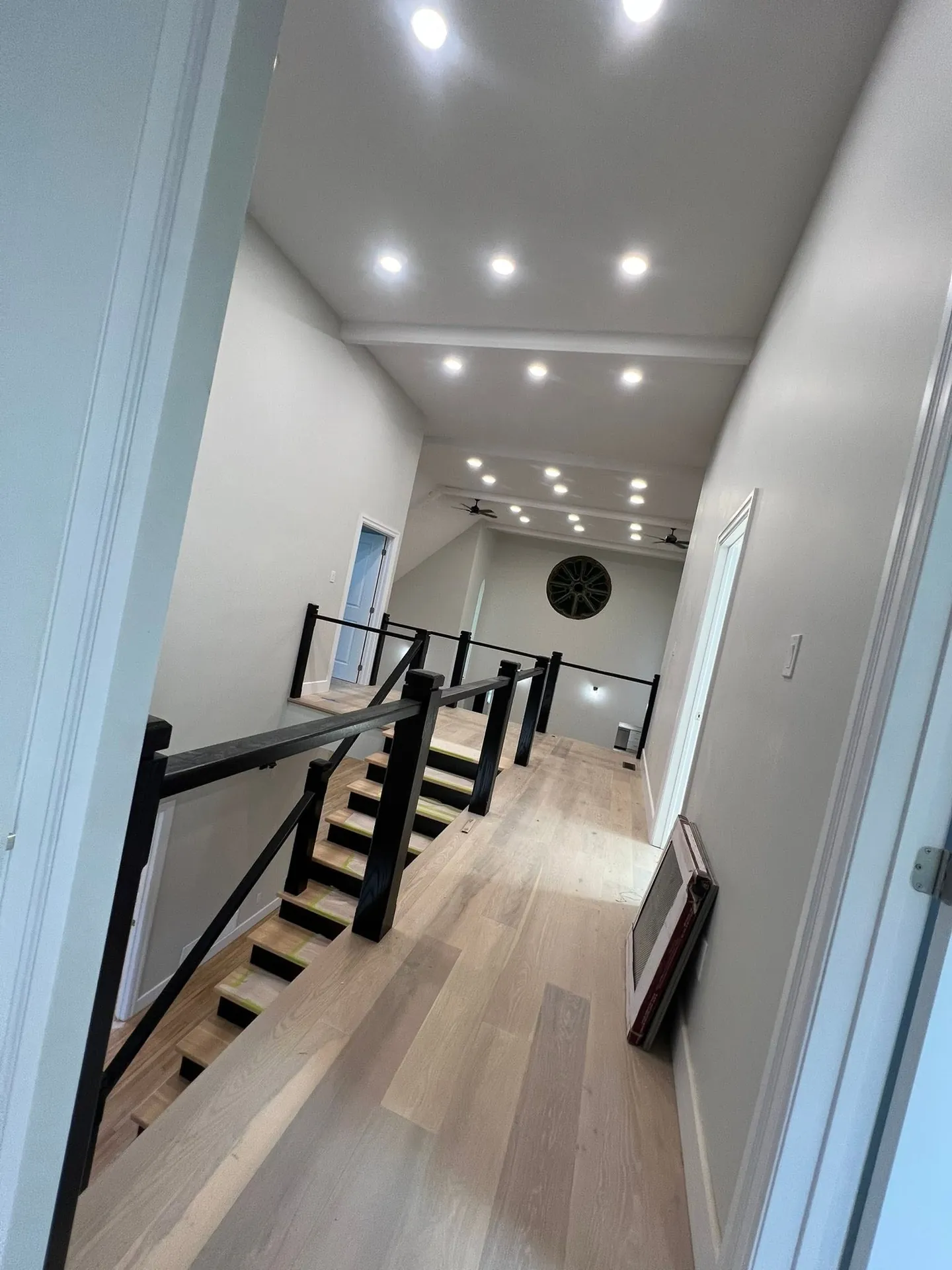Bright upper hallway finished with a continuous row of ceiling pot lights.