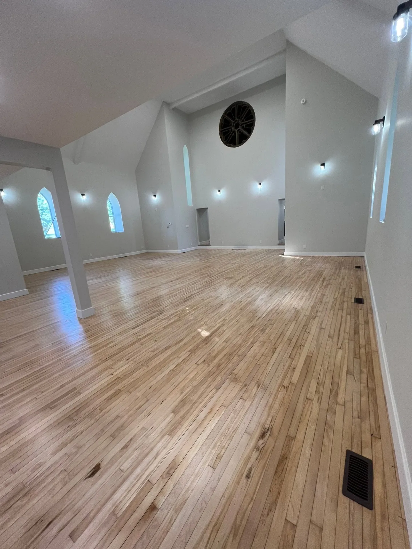 Open-concept living area with hardwood floors and evenly spaced pot lights.