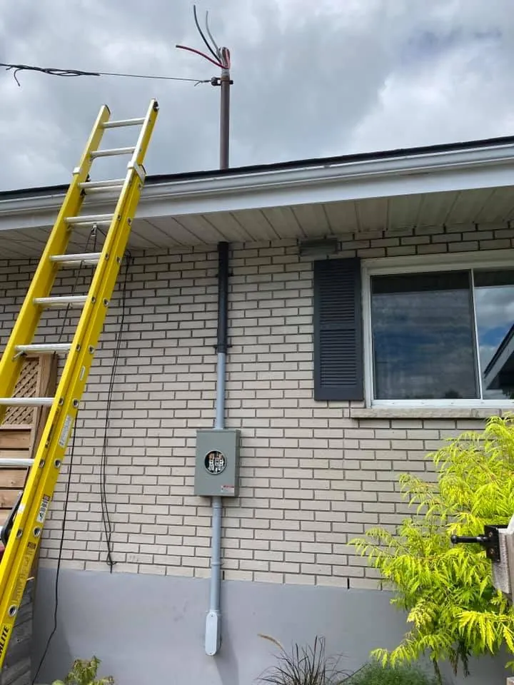 Overhead electrical service mast and meter equipment on a brick home.