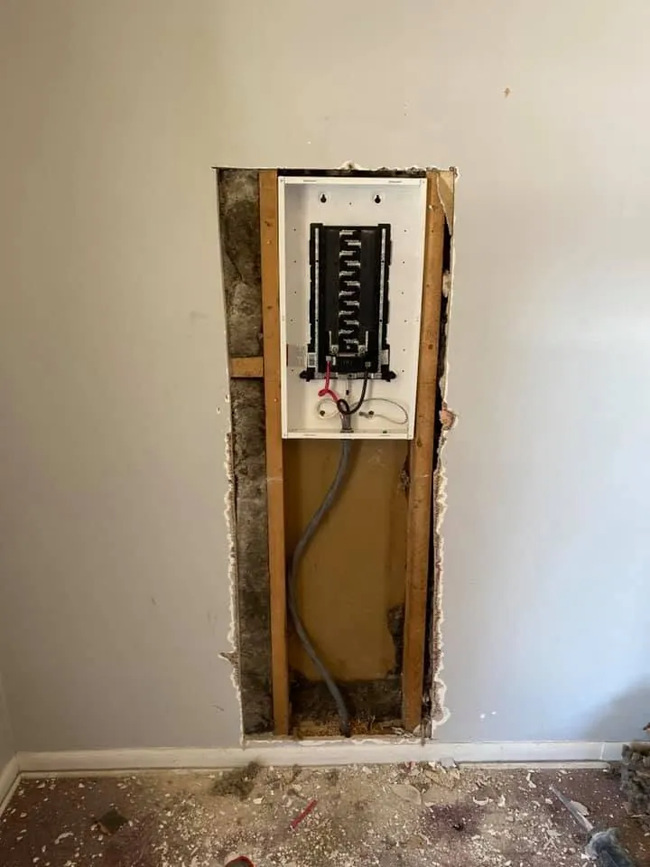 Electrical panel recessed into an opened wall during a home renovation.
