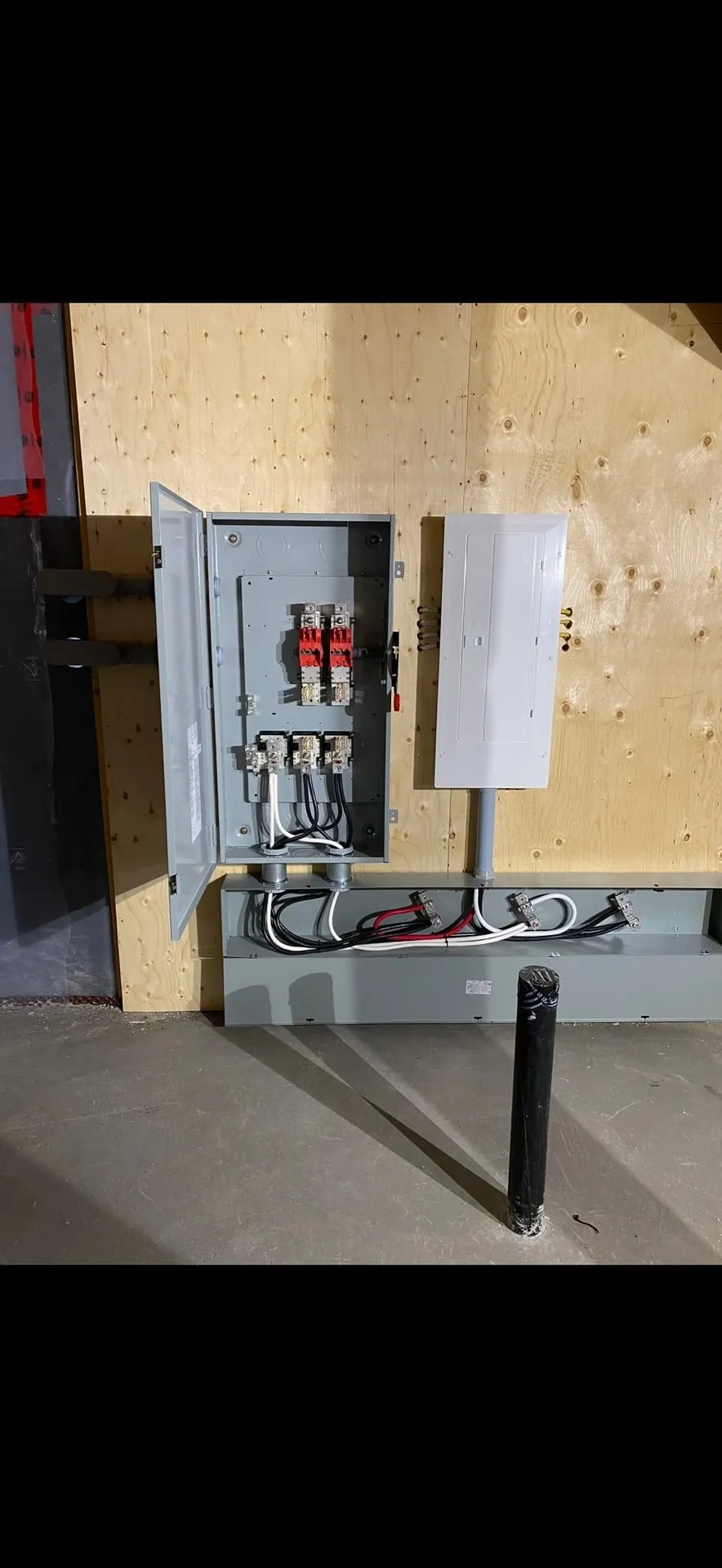 Electrical panel and service equipment mounted on a finished utility-room wall.